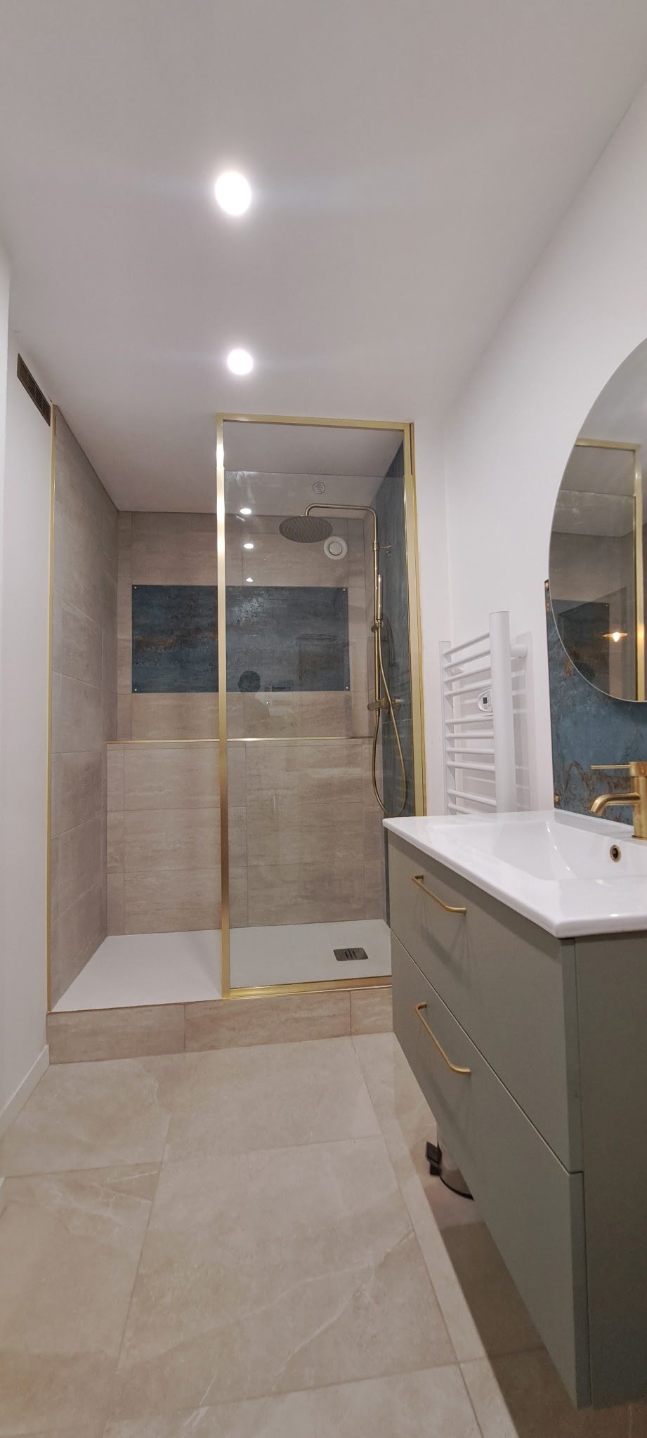 La salle de bain terminée, douche aux parois dorées et teintes minérales